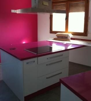 Cocina de muebles blancos con encimeras magenta