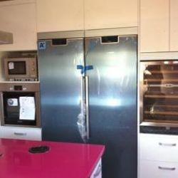 Cocina de encimeras magenta y nevera metálica de dos puertas