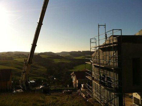 Chalet en construcción con andamios y grúa