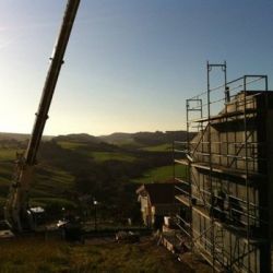 Chalet en construcción con andamios y grúa