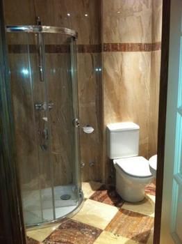 Interior de baño con inodoro y mampara de vidrio